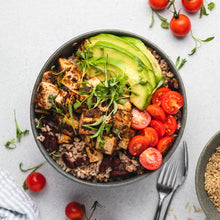 Load image into Gallery viewer, A top-down view of a gray bowl filled with a prepared grain bowl, featuring grilled chicken, sliced avocado, cherry tomatoes, and green herbs, set on a light gray surface with scattered cherry tomatoes and a fork.
